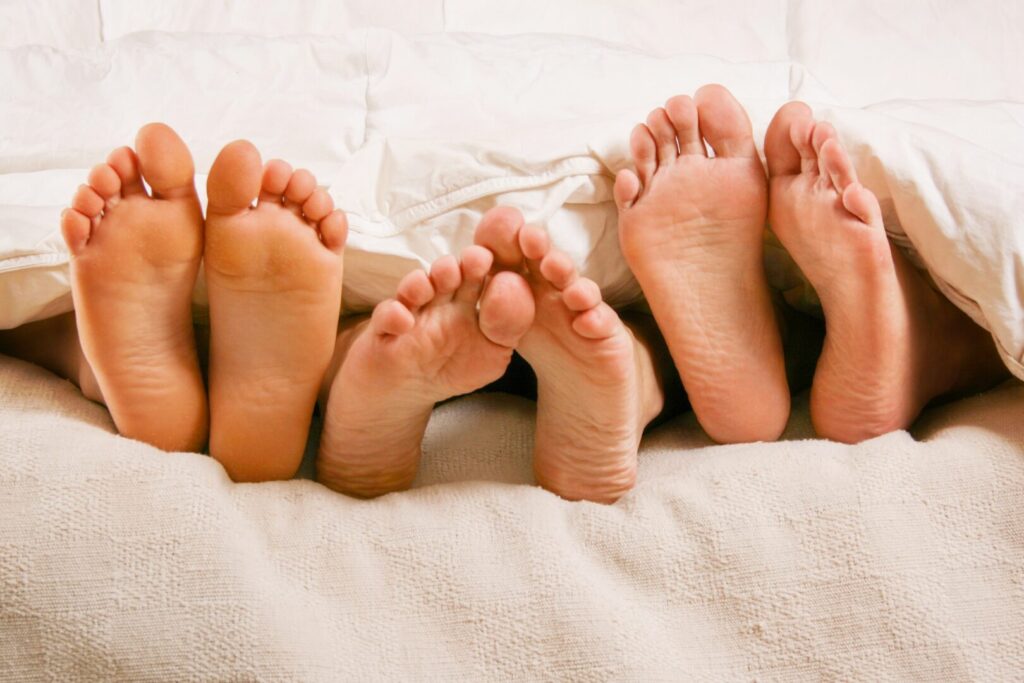 親子の足が布団からはみ出ている